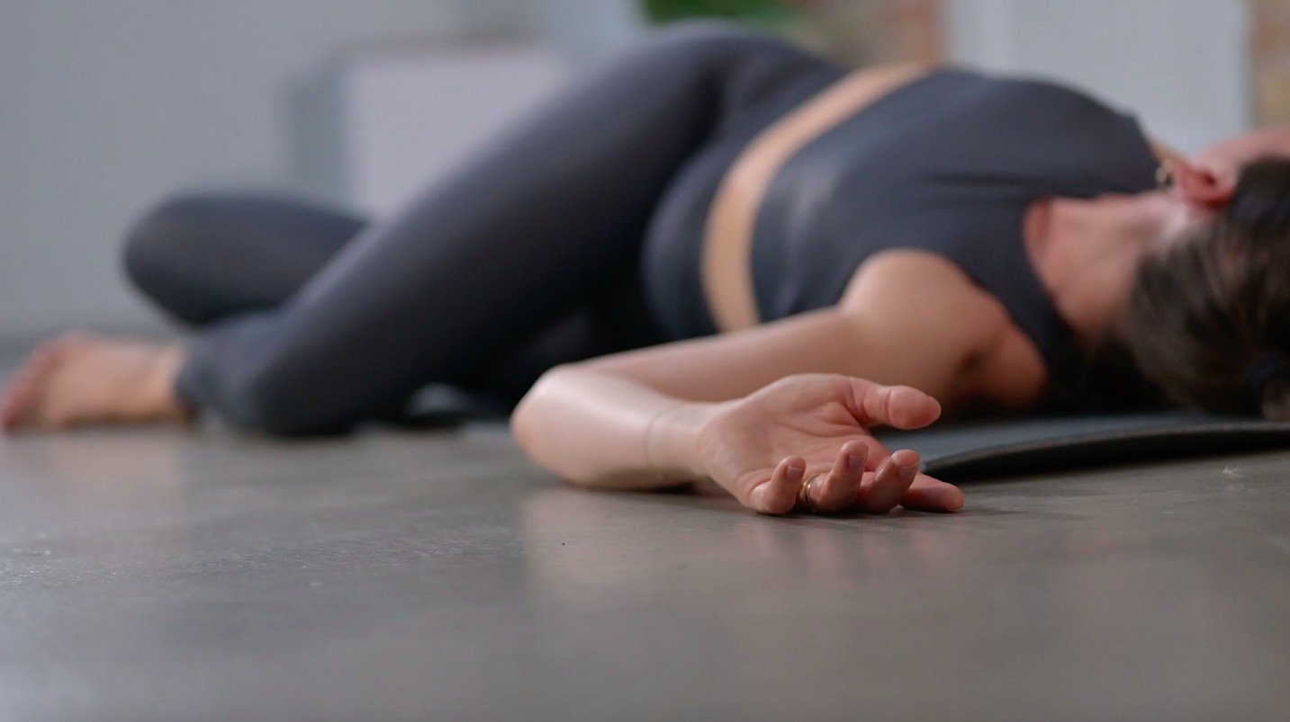 Andrea Foth resting on the floor in a quiet moment of recovery.